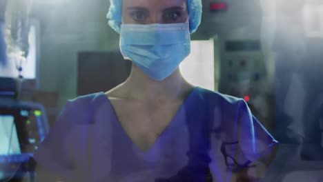 Portrait-of-female-health-worker-wearing-face-mask-at-hospital-against-time-lapse-of-people-walking