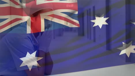 Digitale-Komposition-Der-Australischen-Flagge,-Die-über-Einem-Gestressten-Kaukasischen-Männlichen-Gesundheitspersonal-Im-Krankenhaus-Weht