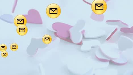 Multiple-message-icons-floating-over-multiple-hearts-falling-against-white-background