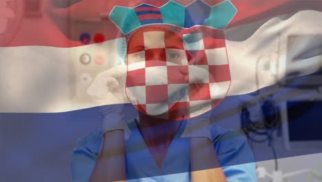 Croatia-flag-waving-against-caucasian-female-health-worker-wearing-face-mask-at-hospital