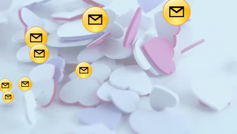 Multiple-message-icons-floating-over-multiple-hearts-falling-against-white-background