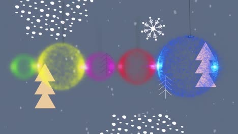 Snow-falling-over-colorful-baubles-hanging-decorations-over-christmas-tree-icons-on-grey-background