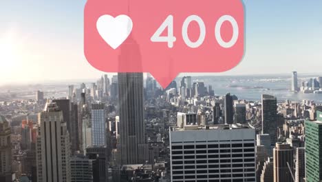 Heart-icon-with-increasing-numbers-on-red-speech-bubble-against-aerial-view-of-cityscape