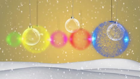 Colorful-baubles-hanging-and-snow-falling-on-winter-landscape-against-yellow-background