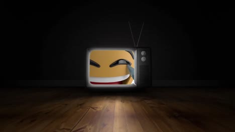 Digital-animation-of-laughing-face-emoji-on-television-screen-on-wooden-surface-on-black-background