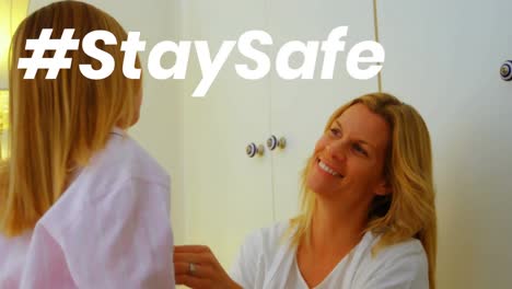 Animation-of-stay-safe-text-over-mother-and-daughter-at-home