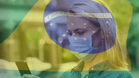 Animation-of-flag-of-brazil-waving-over-woman-in-face-masks