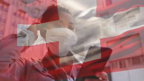 Animation-of-flag-of-switzerland-waving-over-woman-in-face-masks