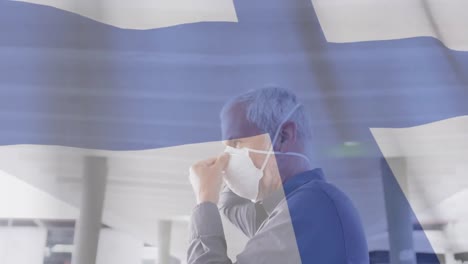 Animation-of-flag-of-finland-waving-over-man-in-face-masks
