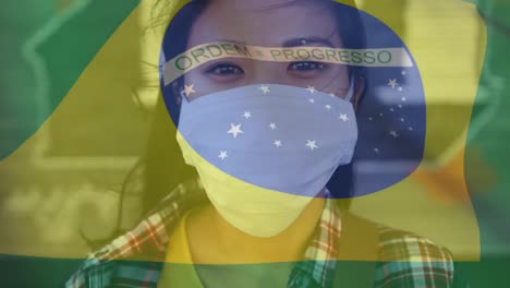 Animation-of-flag-of-brazil-waving-over-woman-in-face-masks