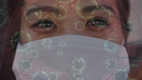 Animation-Von-Covid-19-Zellen,-Die-Sich-über-Eine-Frau-Mit-Gesichtsmaske-Bewegen