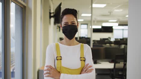 Portrait-of-caucasian-creative-businesswoman-wearing-face-mask-looking-at-camera