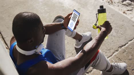 Man-in-street-holding-smartphone-with-covid-vaccination-certificate-and-qr-code-on-screen