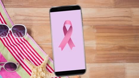 Animation-of-pink-breast-cancer-ribbon-logo-on-smartphone-screen