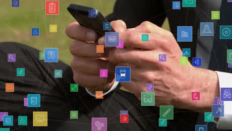 Animation-of-network-of-connections-with-icons-over-businessman-using-smartphone