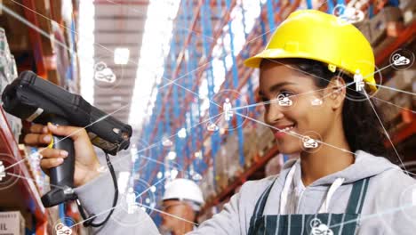 Animation-of-networks-of-connections-with-icons-over-woman-working-in-warehouse