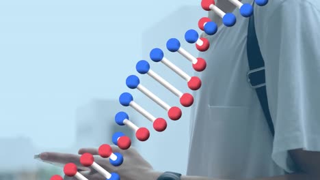 Animation-of-dna-strand-spinning-over-man-using-smartphone