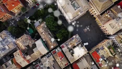 Animation-of-connections-moving-over-aerial-view-of-modern-city-buildings