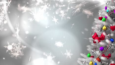 Animation-of-decorated-white-christmas-tree,-with-falling-snowflakes-and-glowing-lights-on-grey