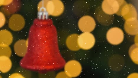 Animation-of-snow-falling-over-christmas-red-bell-and-spots-decorations