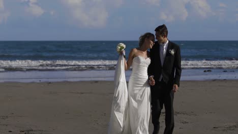 Glückliches-Frisch-Verheiratetes-Paar,-Das-Am-Strand-Spaziert
