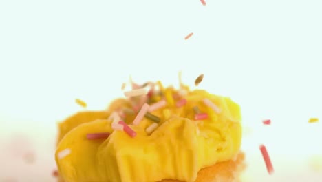 Sprinkles-pouring-onto-yellow-frosting
