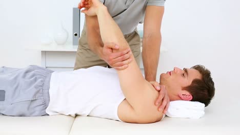 Physiotherapeut-Bewegt-Patienten-Mit-Verletzter-Schulter