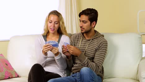 Nettes-Glückliches-Paar,-Das-Zusammen-Auf-Der-Couch-Karten-Spielt