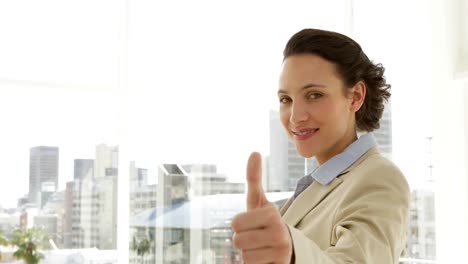 Smiling-businesswoman-giving-thumbs-up