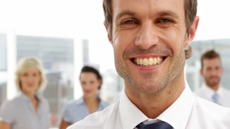 Businessman-smiling-in-front-of-his-team
