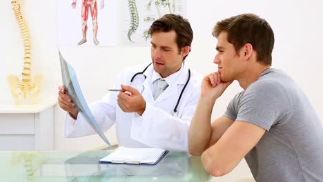 Earnest-doctor-discussing-xray-with-his-patient