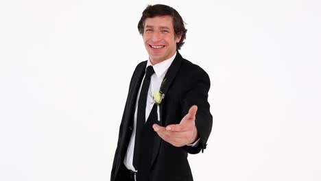 Groom-offering-his-hand-smiling-at-camera