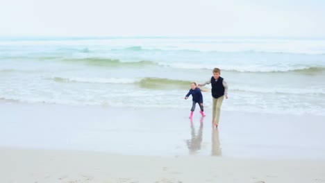 Siblings-running-towards-the-sea-on-the-beach