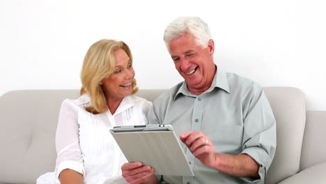 Retired-couple-using-their-tablet-on-the-couch
