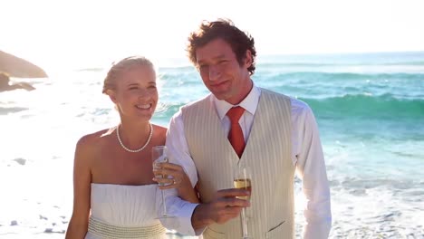 Newlyweds-drinking-champagne-on-the-beach