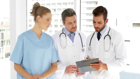 Medical-team-discussing-paperwork-on-clipboard