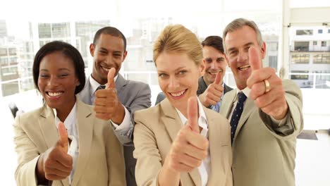 Business-people-giving-thumbs-up-to-camera