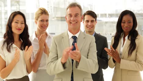 Business-team-smiling-at-camera-and-clapping