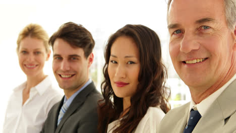 Business-team-smiling-at-camera-with-arms-folded