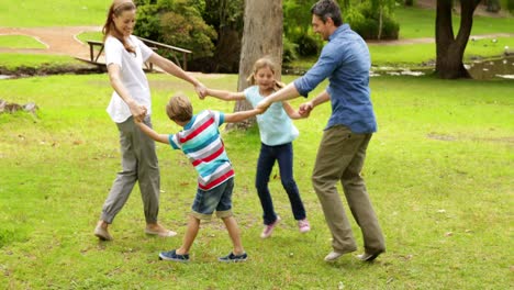 Happy-family-playing-ring-a-rosie-in-the-park-together