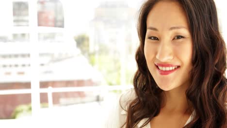 Asian-businesswoman-smiling-at-camera-with-arms-crossed