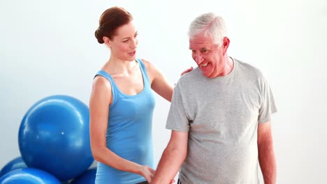 Älterer-Mann,-Der-Mit-Hilfe-Seines-Trainers-Handgewichte-Hebt