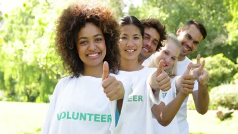 Volunteers-standing-in-a-row-giving-smiling-at-camera