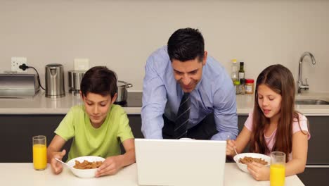 Lächelnder-Vater-Benutzt-Laptop-Mit-Kindern,-Bevor-Er-Zur-Arbeit-Geht
