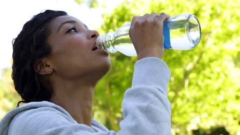 Glückliche,-Fitte-Brünette,-Die-Eine-Pause-Macht-Und-Einen-Schluck-Wasser-Trinkt