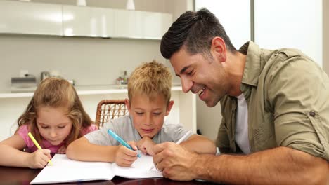 Children-drawing-with-their-dad-at-the-table