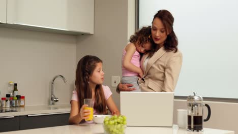 Smiling-working-mother-with-her-children-at-breakfast