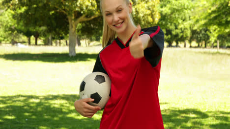 Blonde-football-player-smiling-and-giving-thumbs-up-to-camera