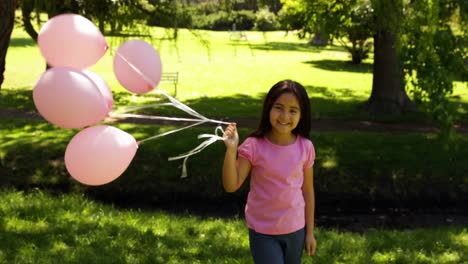 Kleines-Mädchen-Trägt-Luftballons-Zur-Brustkrebsaufklärung-Im-Park