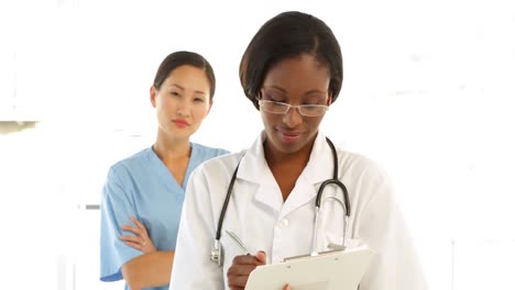 Nurse-going-over-a-file-and-smiling-at-colleague